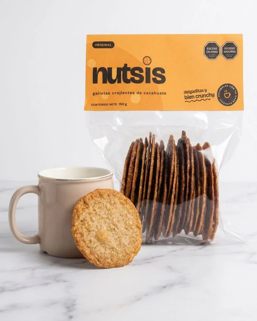 Bolsa de Nutsis Original, galletas crujientes de cacahuate, junto a una taza de café